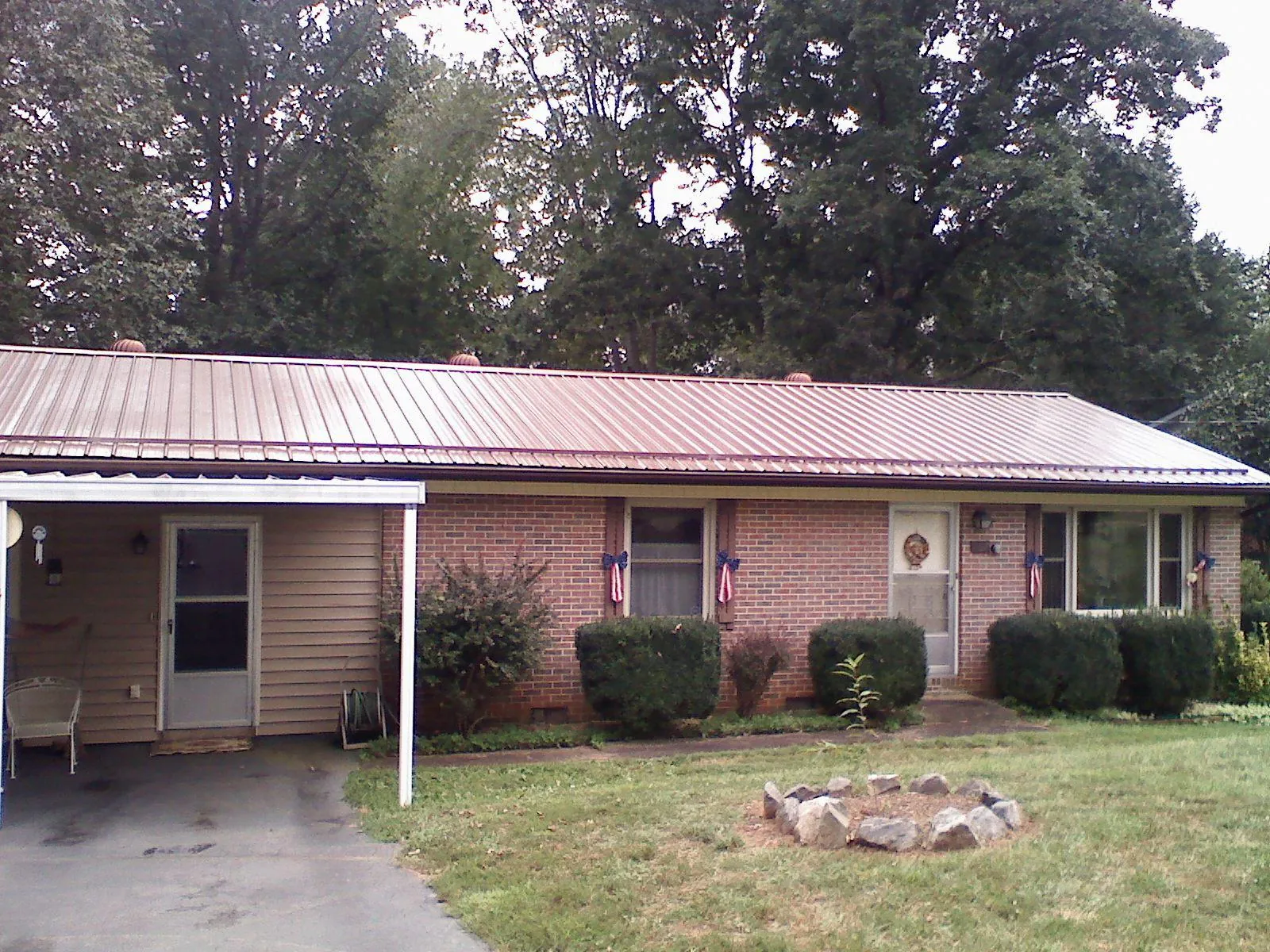 Bronze metal roof and carport on a brick ranch home — Roof Repair work by our crew in Stanardsville
